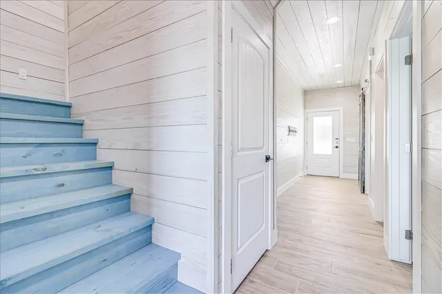 a view of a hallway with wooden floor and staircase