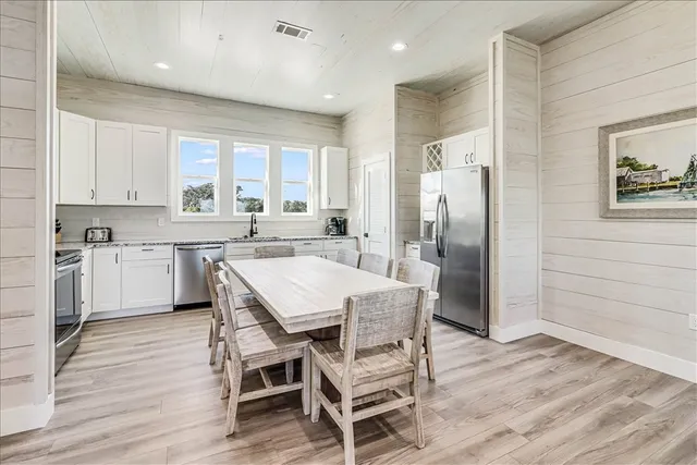 a kitchen with a table chairs refrigerator and cabinets