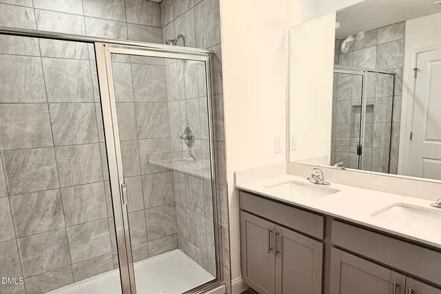 a bathroom with a shower and a sink mirror