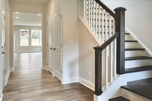 a view of a hallway with wooden floor and staircase