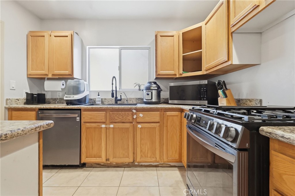 1540 East Wardlow Road Long Beach, CA 90807 - Photo 9 of 38 a kitchen with stainless steel appliances granite countertop a sink stove and cabinets