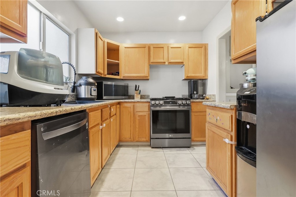1540 East Wardlow Road Long Beach, CA 90807 - Photo 10 of 38 a kitchen with stainless steel appliances granite countertop a stove a sink and a refrigerator