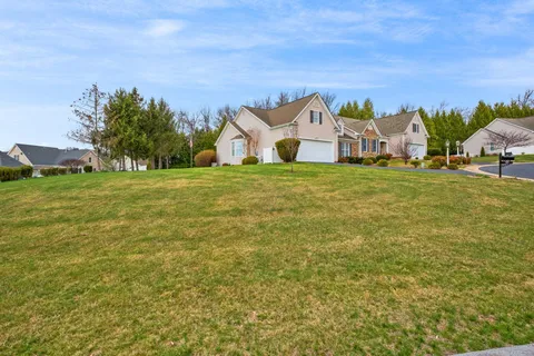 a front view of a house with a yard and trees