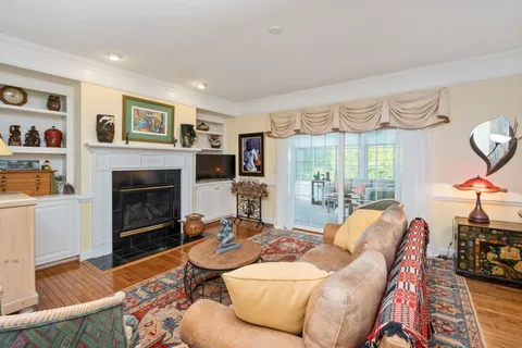 a living room with furniture a large window and a fireplace