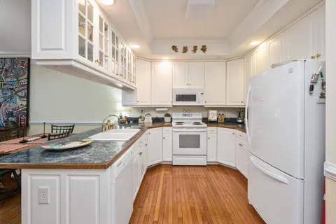 a kitchen with granite countertop stainless steel appliances a sink and cabinets