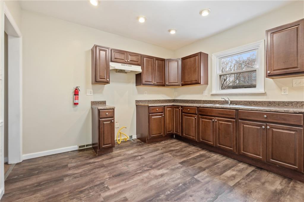 912 2nd Street McKees Rocks, PA 15136 - Photo 7 of 24 a kitchen with stainless steel appliances granite countertop a sink cabinets and wooden floor