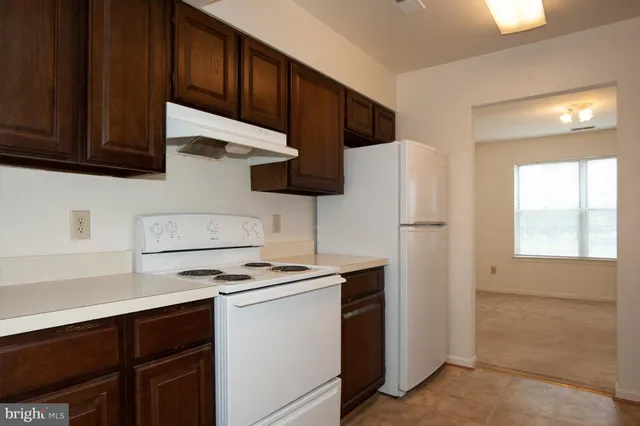 a kitchen with stainless steel appliances a refrigerator a stove a sink cabinets and a counter space