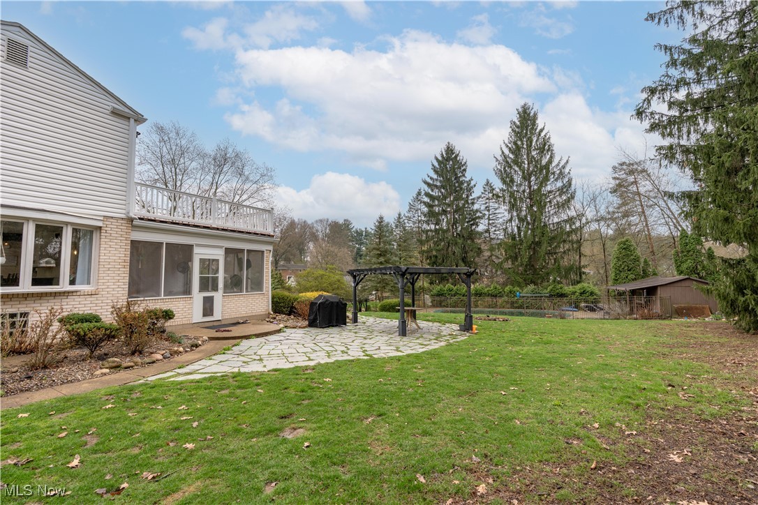 2119 Devonshire Road Northwest Canton, OH 44708 - Photo 42 of 46 View of yard featuring a patio, a balcony off owners suite, pergola, sunroom, and outbuilding/shed