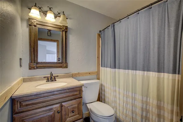 a bathroom with a sink a toilet and mirror