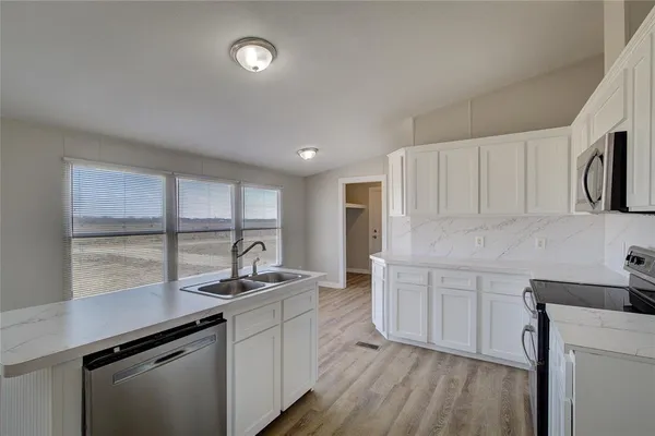 a kitchen with a sink cabinets and window