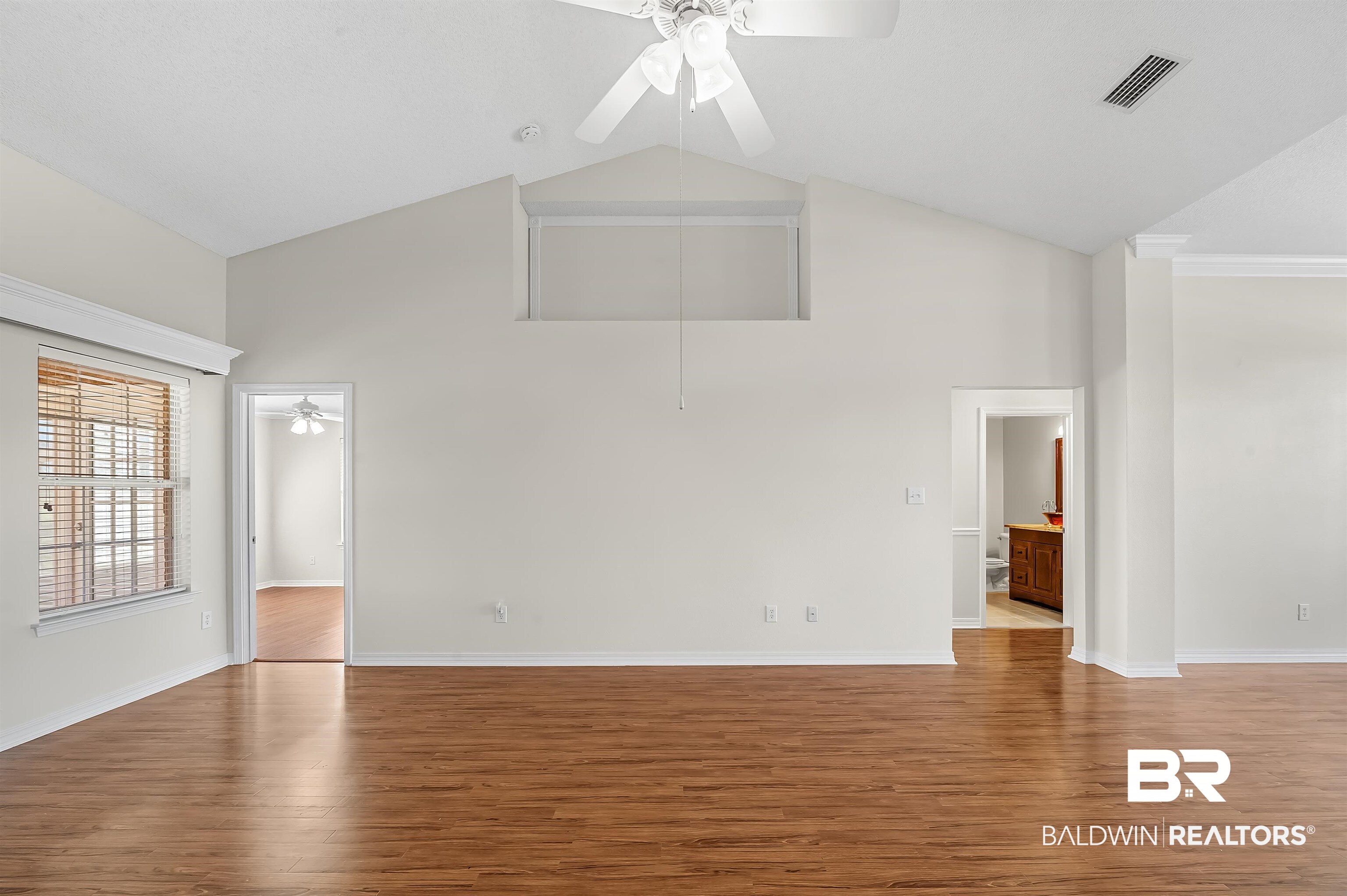 421 Collinwood Loop Foley, AL 36535 - Photo 33 of 62 Unfurnished living room featuring crown molding, ceiling fan, high vaulted ceiling, and light wood-type flooring