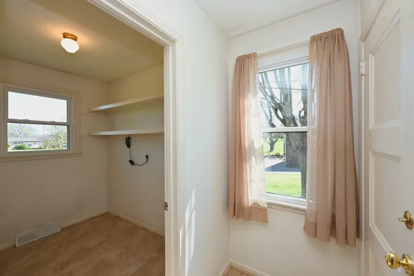 a view of an empty room with a fireplace and a window