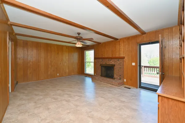 a living room with a fireplace and a floor to ceiling window