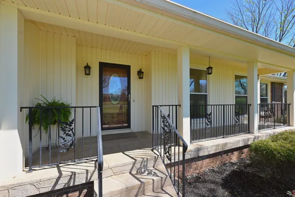 a view of a porch with chairs and potted plants