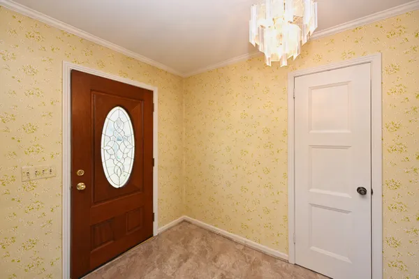 a view of a hallway with wooden floor and front door