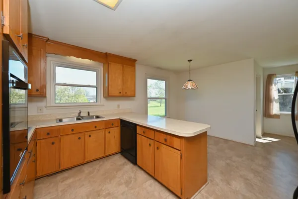 a kitchen with stainless steel appliances granite countertop a refrigerator a sink and dishwasher