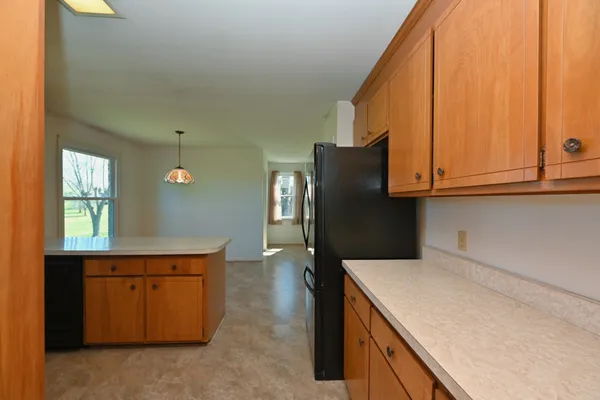 a kitchen with stainless steel appliances granite countertop a refrigerator a sink a stove and a wooden floors