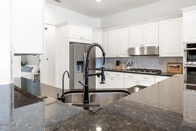 a kitchen with stainless steel appliances kitchen island a refrigerator sink and cabinets