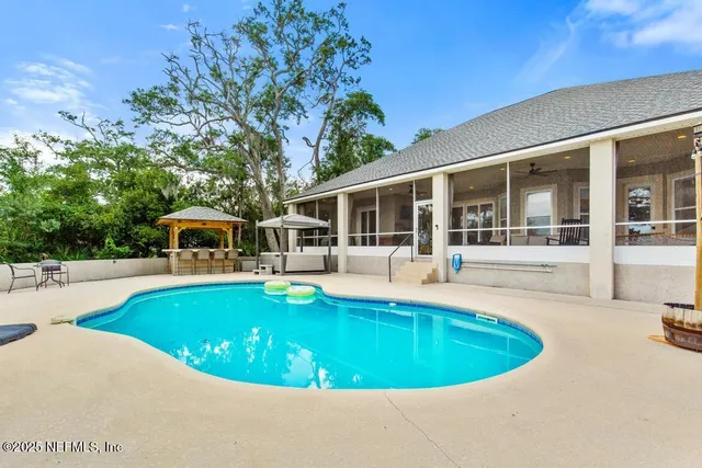 a view of a house with swimming pool and sitting area