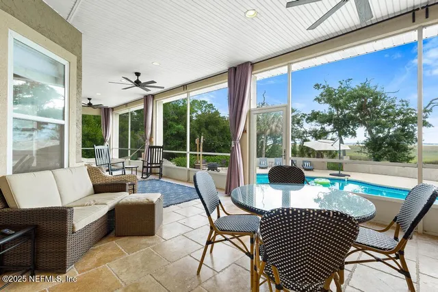 a living room with patio furniture and a floor to ceiling window