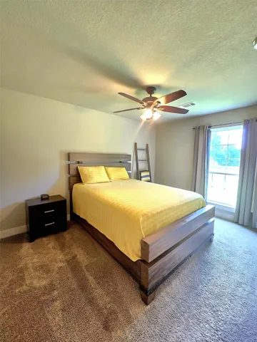 a living room with furniture and a ceiling fan