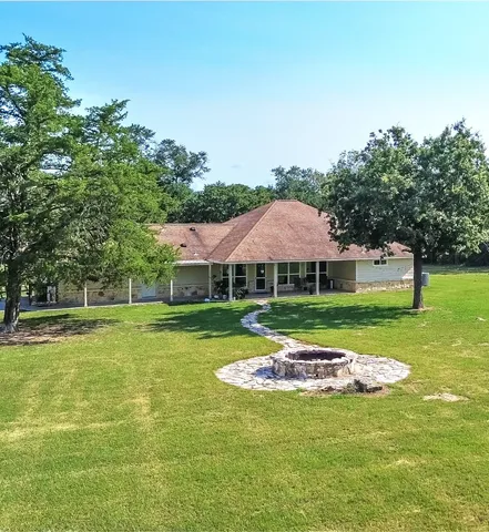 an aerial view of a house with a garden and lake view