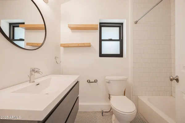 a bathroom with a bathtub sink mirror and toilet