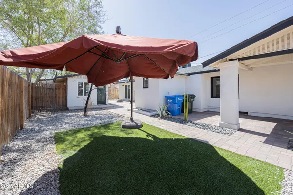a view of a house with backyard and sitting area
