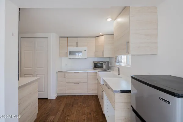 a kitchen with white cabinets and appliances