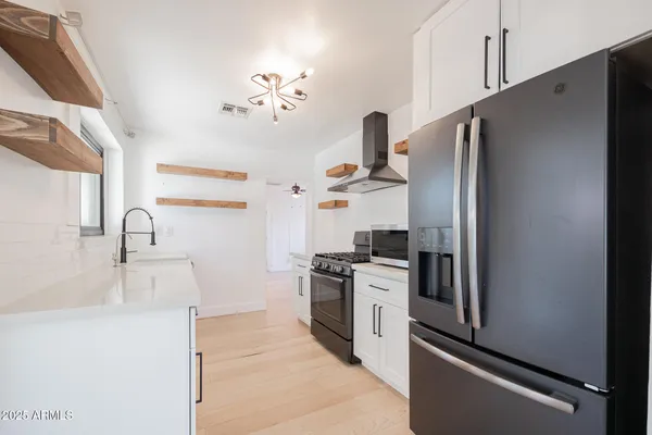 a kitchen with stainless steel appliances granite countertop a refrigerator and a sink