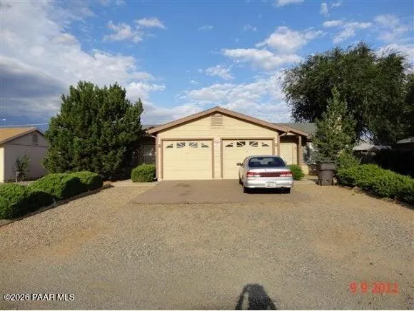 a view of a car parked in front of a house with a big yard