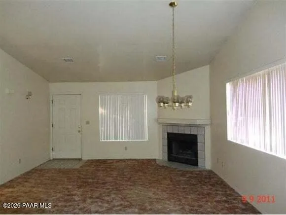 a view of an empty room with a fireplace and a window