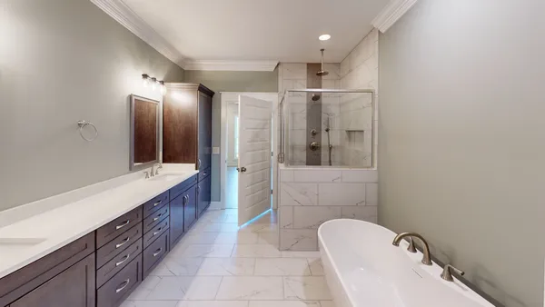 a bathroom with a double vanity sink and mirror with bathtub