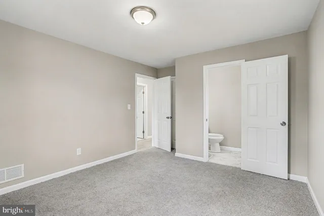 a view of an empty room and a bathroom