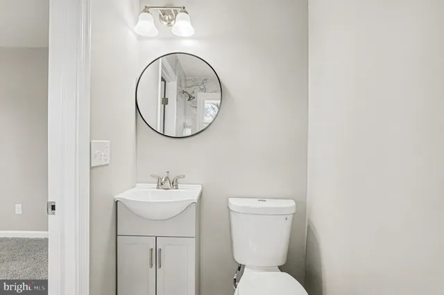 a bathroom with a toilet sink and mirror