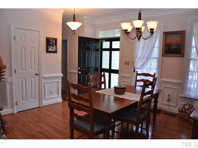 9313 Cub Trail Raleigh, NC 27615 - Photo 3 of 23 Spacious, neutral dining room with hardwood floor, heavy chair rail, wainscoting, updated light fixture