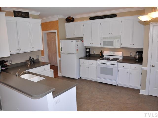 9313 Cub Trail Raleigh, NC 27615 - Photo 4 of 23 Updated kitchen with solid-surface countertops, tile floor, a plethora of upgraded cabinets, gas range, microwave, dishwasher, updated lighting, separate pantry, bay window/breakfast nook.