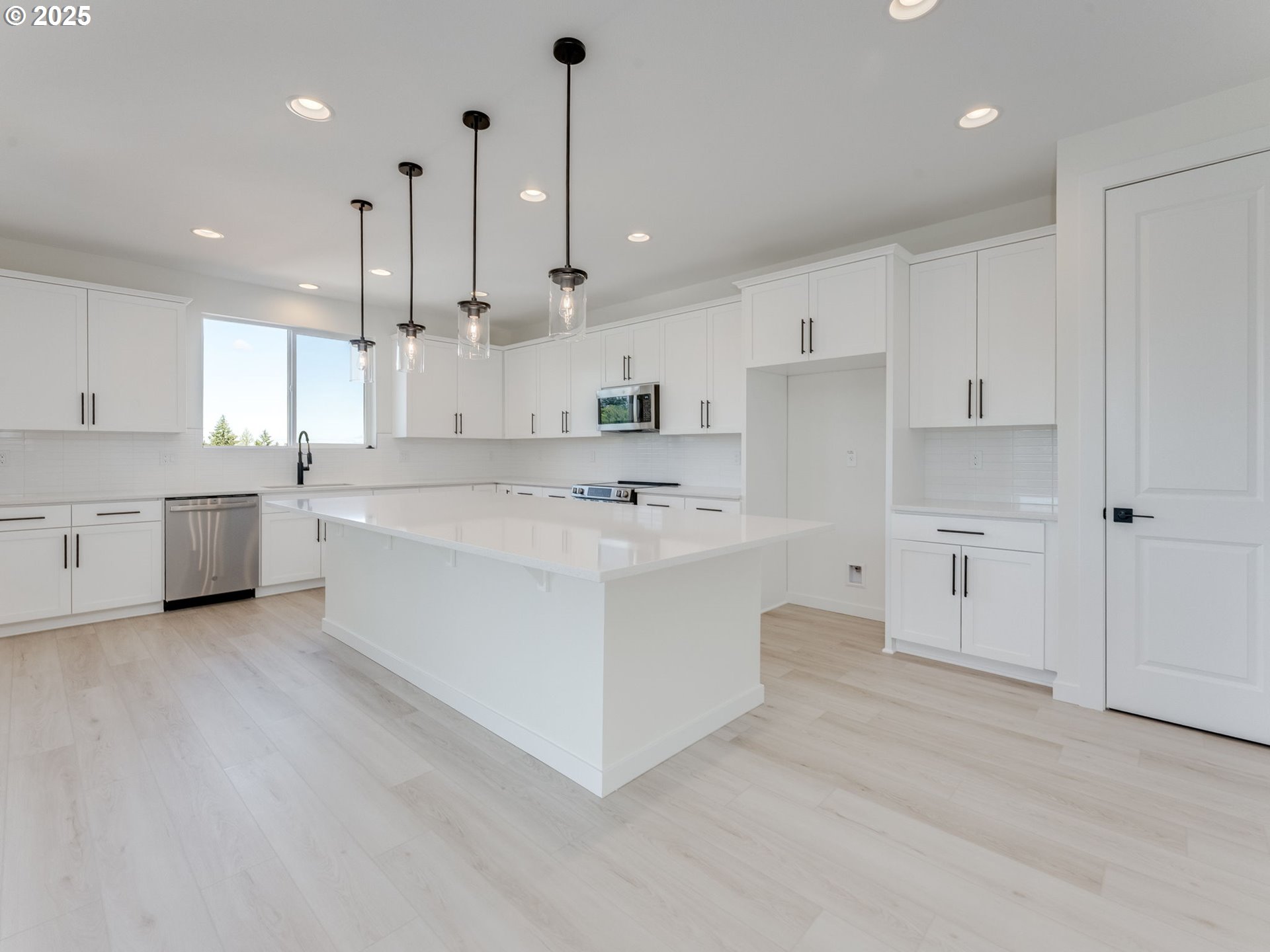 2151 Northeast Ridge Run Lane Estacada, OR 97023 - Photo 17 of 46 a large white kitchen with kitchen island a sink a center island stainless steel appliances and a cabinets