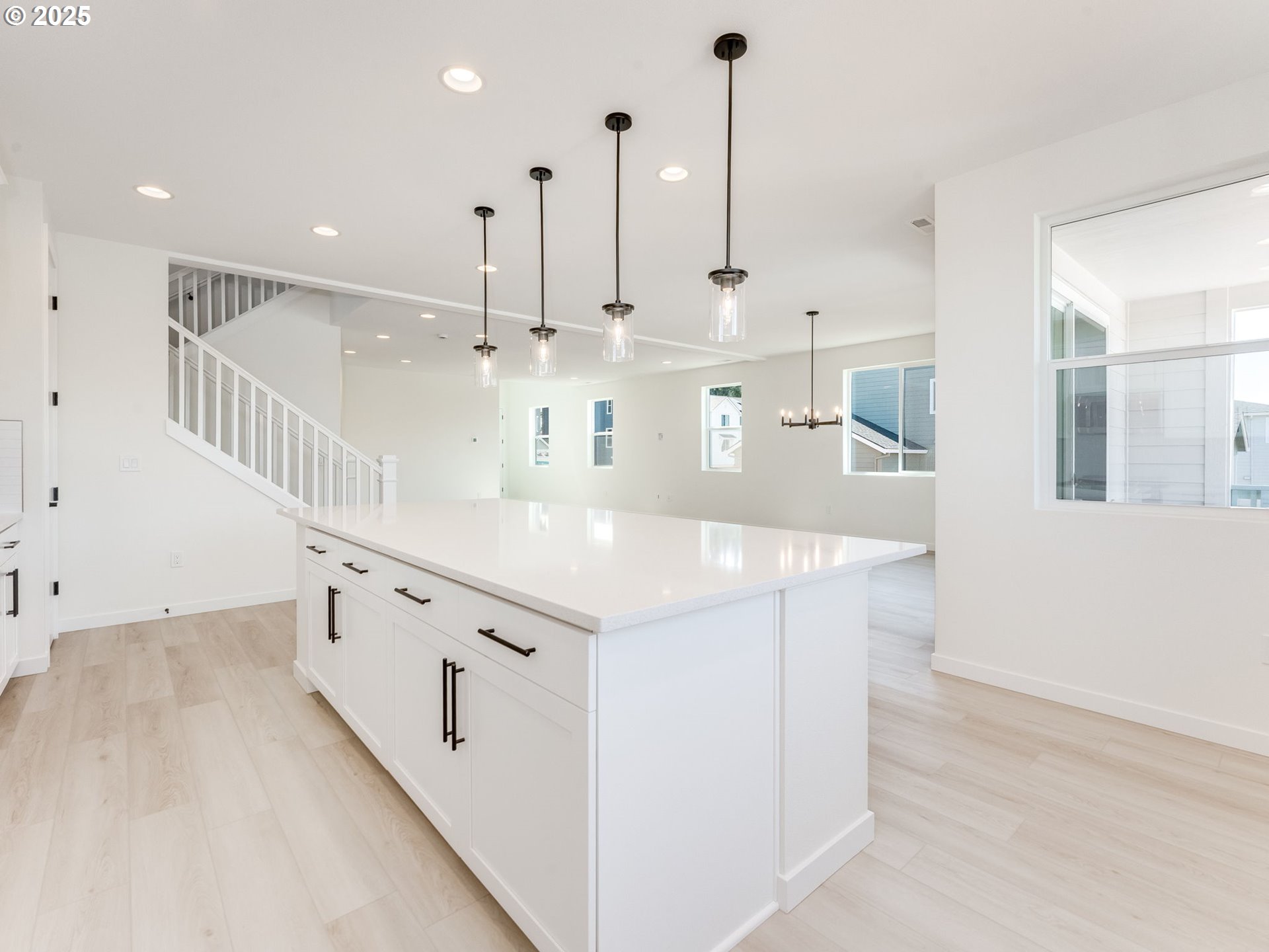 2151 Northeast Ridge Run Lane Estacada, OR 97023 - Photo 21 of 46 a large white kitchen with kitchen island a sink a center island and wooden floor