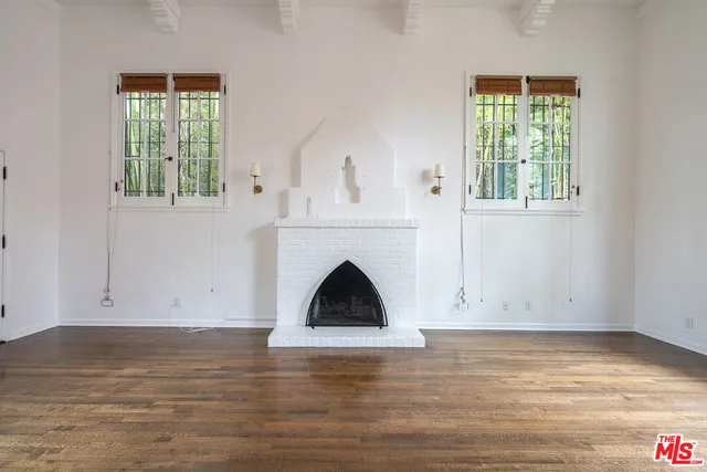 a view of a livingroom with wooden floor and a fireplace