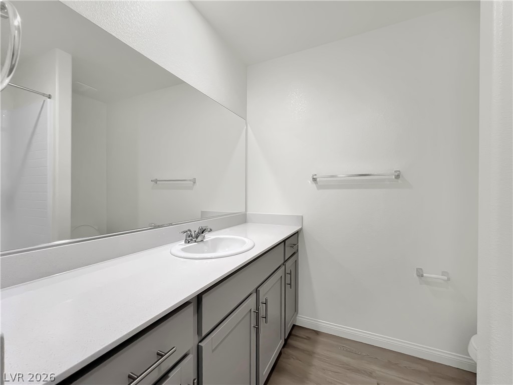 9984 Indigo Cliffs Street Las Vegas, NV 89141 - Photo 24 of 31 Bathroom with baseboards, toilet, wood finished floors, and vanity