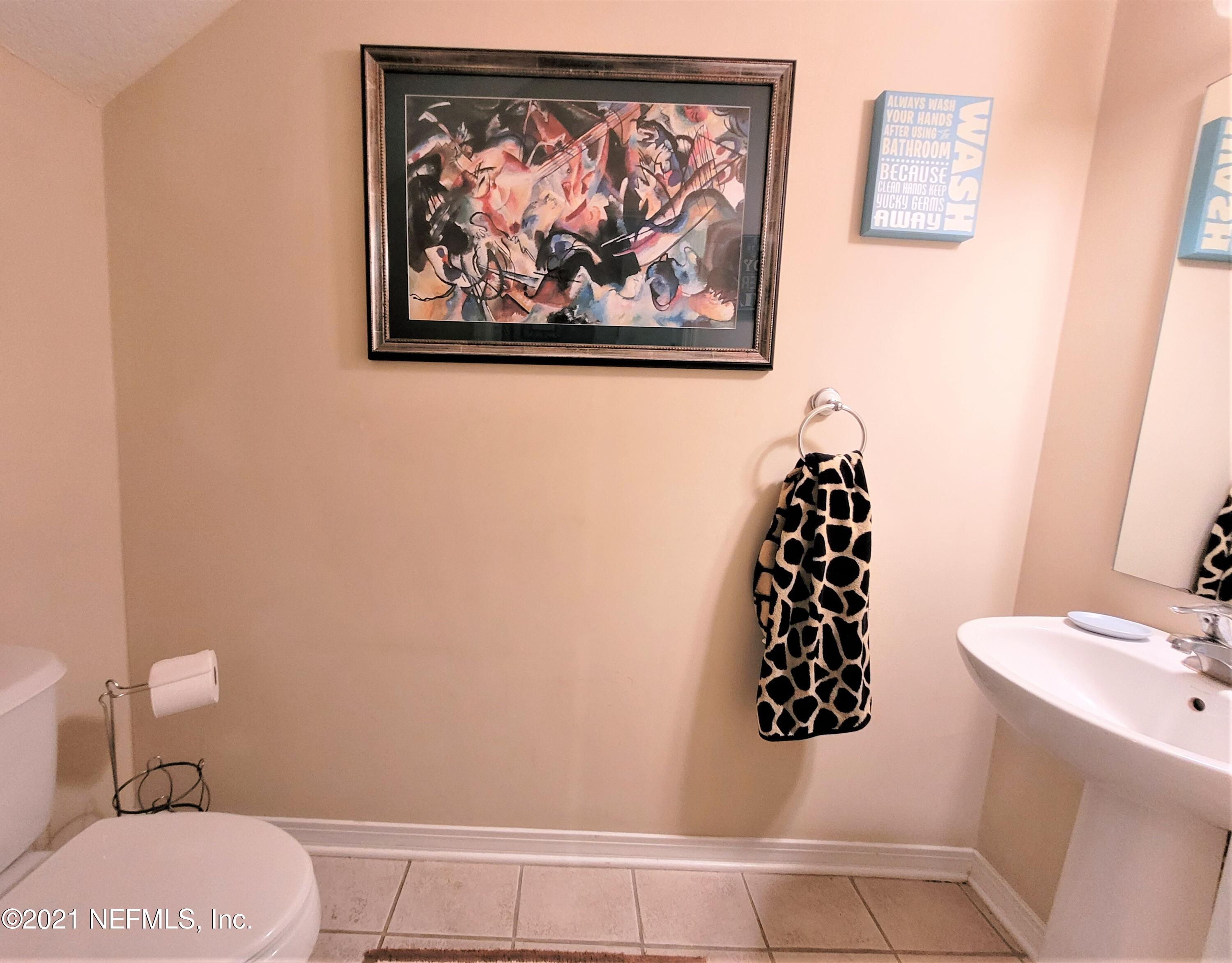 2190 Monument Road, Unit 104 Jacksonville, FL 32225 - Photo 11 of 27 a bathroom with a toilet and a shower curtain