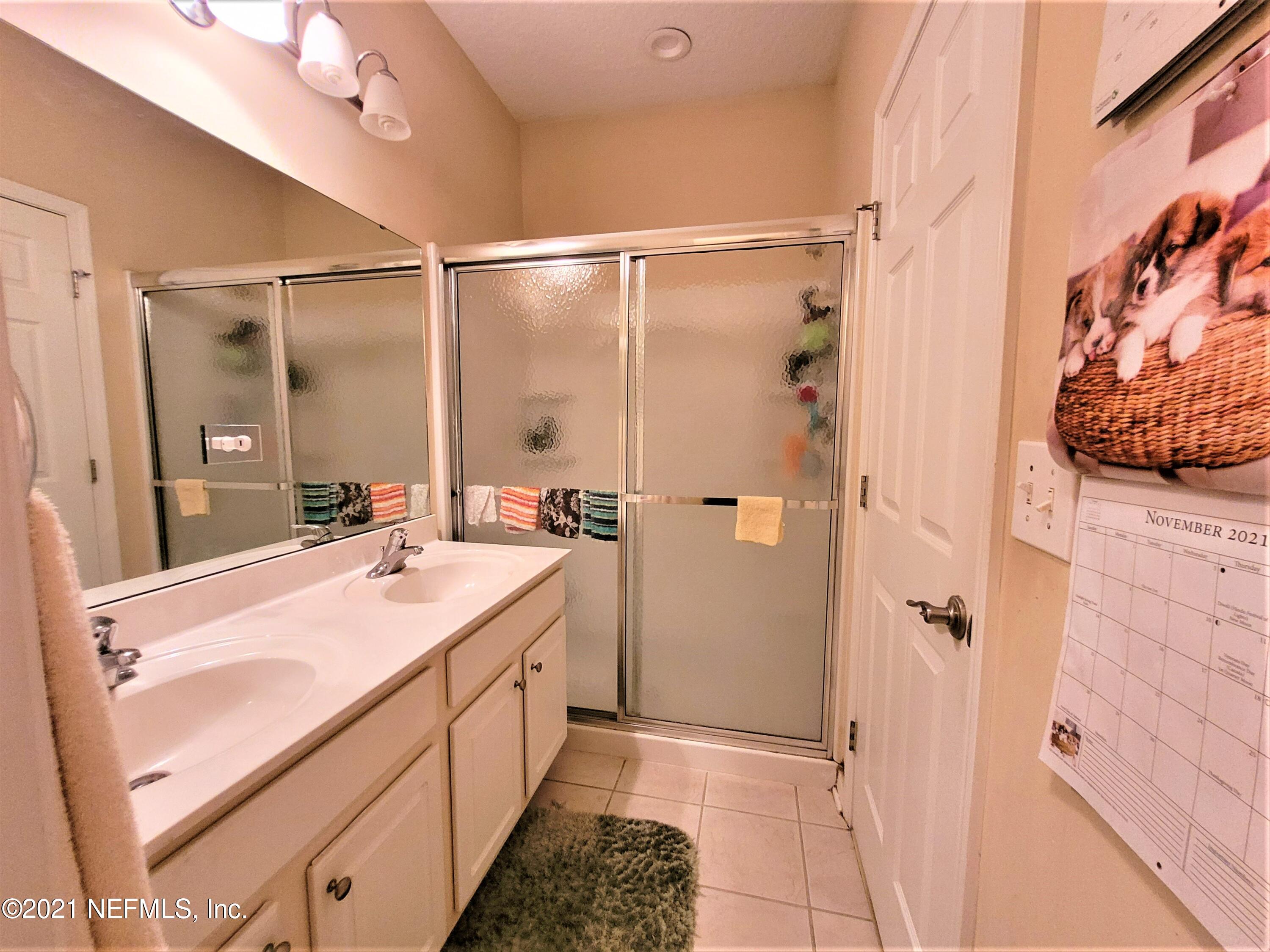 2190 Monument Road, Unit 104 Jacksonville, FL 32225 - Photo 16 of 27 a bathroom with a double vanity sink mirror and shower