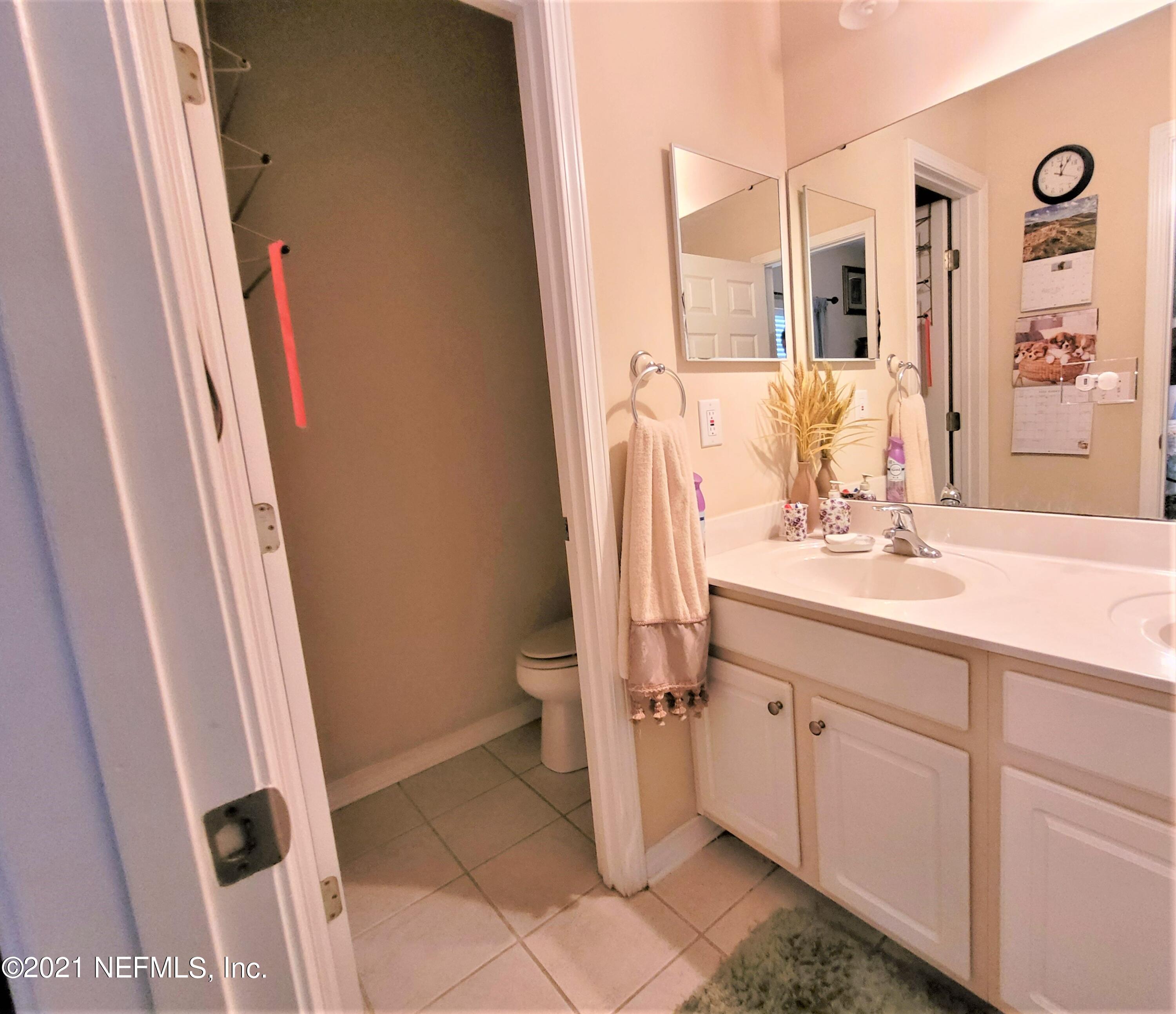 2190 Monument Road, Unit 104 Jacksonville, FL 32225 - Photo 17 of 27 a bathroom with a sink a toilet and a mirror