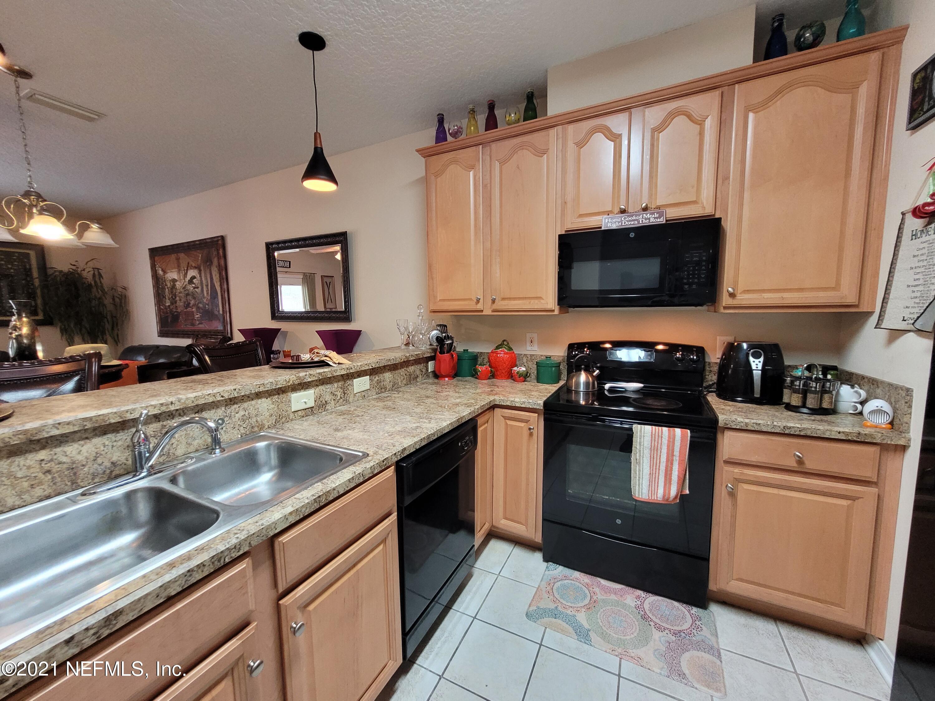 2190 Monument Road, Unit 104 Jacksonville, FL 32225 - Photo 5 of 27 a kitchen with granite countertop a sink stainless steel appliances and cabinets
