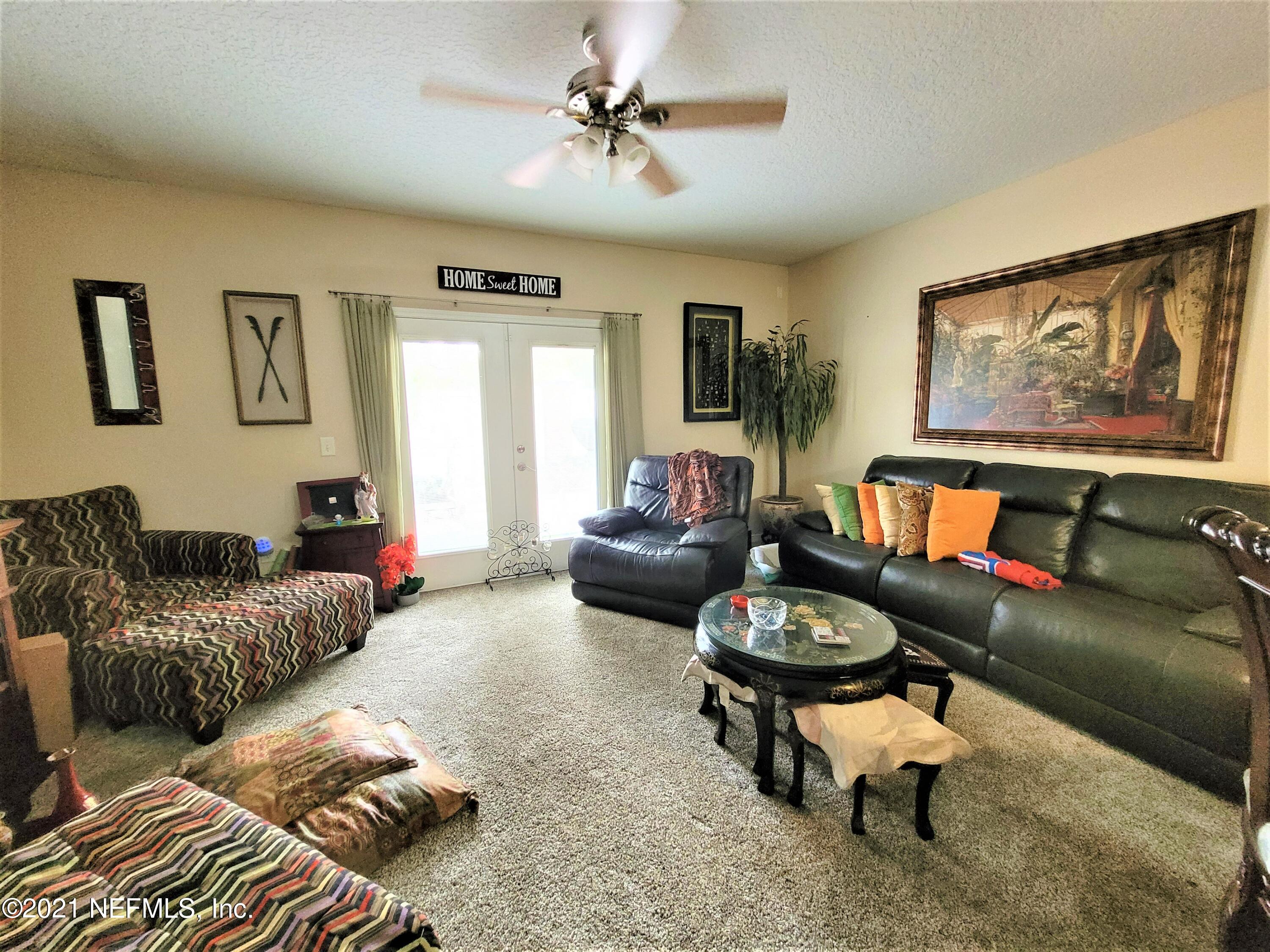 2190 Monument Road, Unit 104 Jacksonville, FL 32225 - Photo 7 of 27 a living room with furniture a rug and white walls