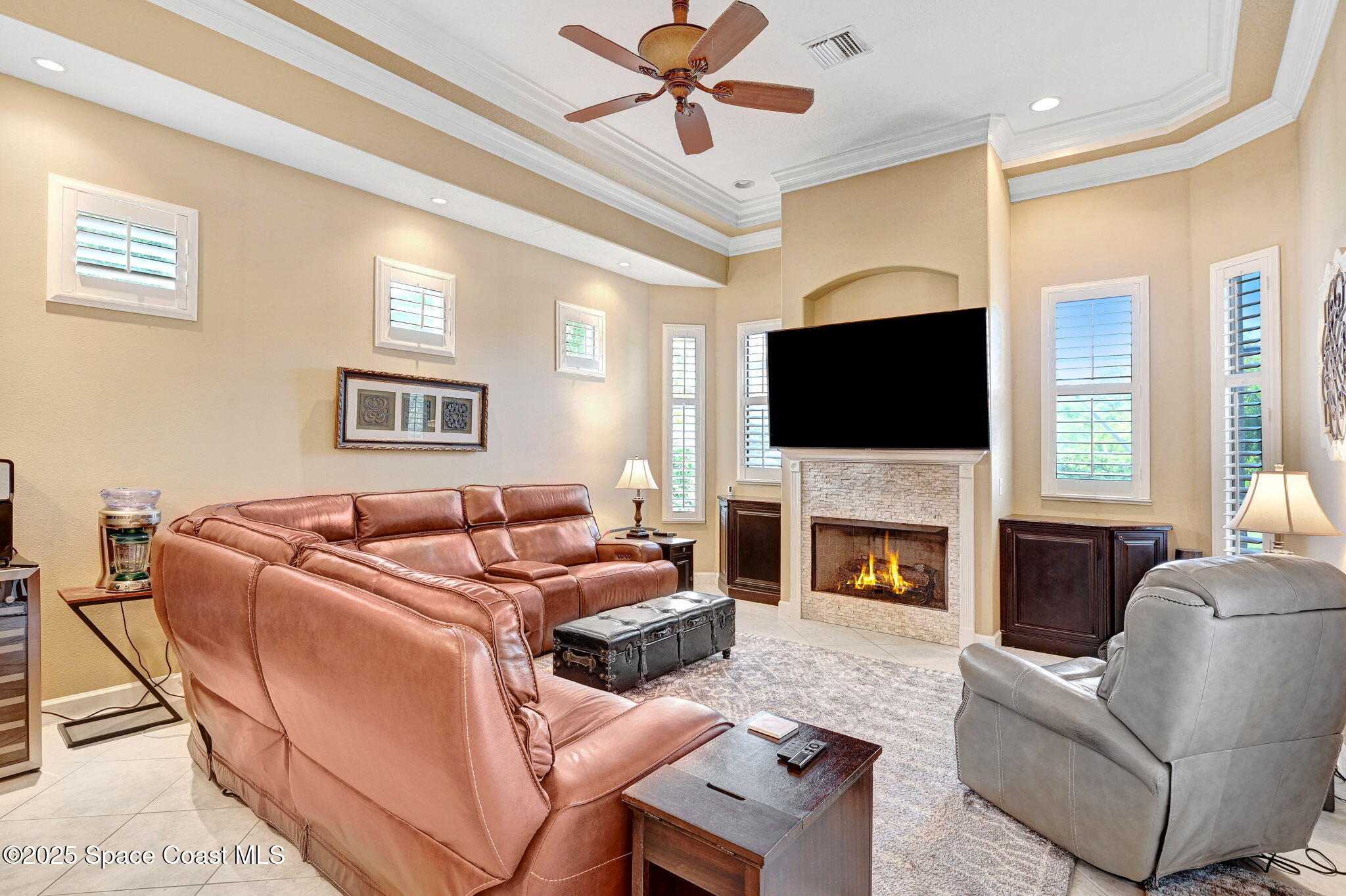 1418 Southpointe Court Melbourne, FL 32940 - Photo 27 of 52 a living room with furniture a fireplace and a flat screen tv