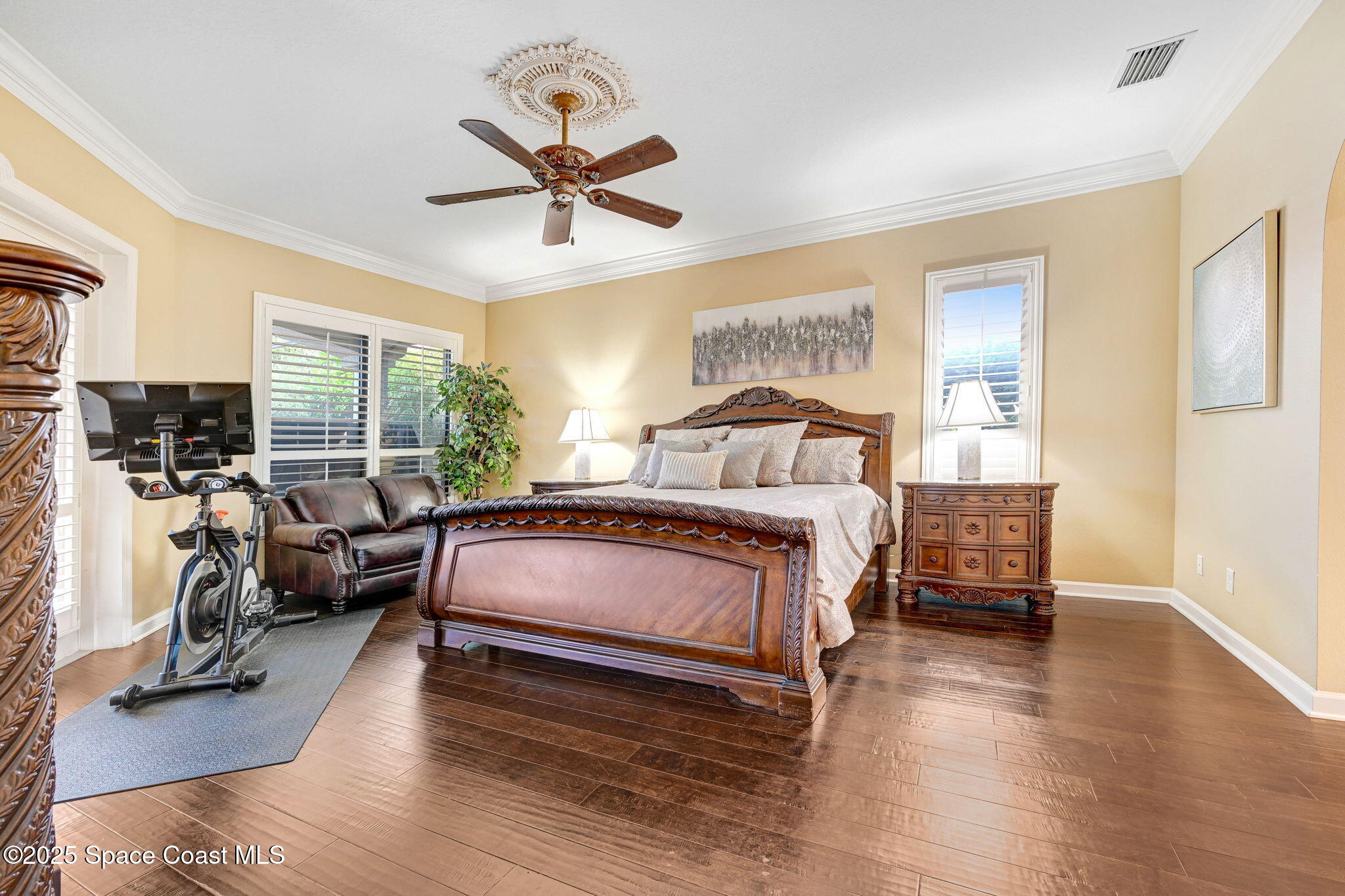 1418 Southpointe Court Melbourne, FL 32940 - Photo 31 of 52 a bedroom with a bed a couch and large window