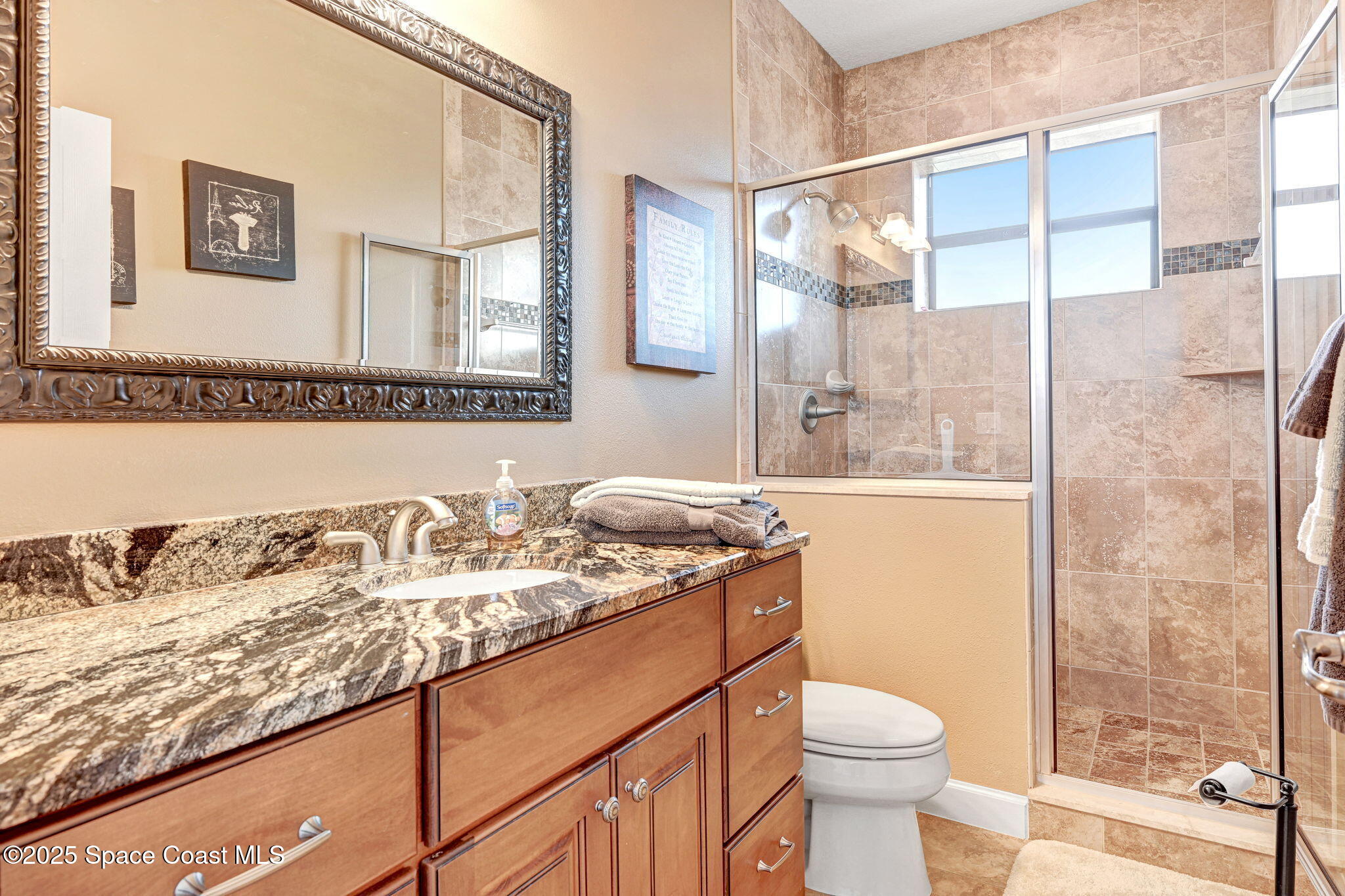 1418 Southpointe Court Melbourne, FL 32940 - Photo 47 of 52 a bathroom with a granite countertop sink a toilet and a mirror