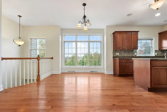 a view of a kitchen with a stove wooden floor and a window